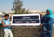 ابناء المعتقلين يرفعان لافتة تندد بمحاكمة المدنيين.jpg
